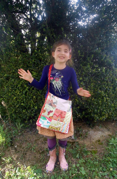 A 7 ans, avec le sac en patchwork qu'elle a cousu